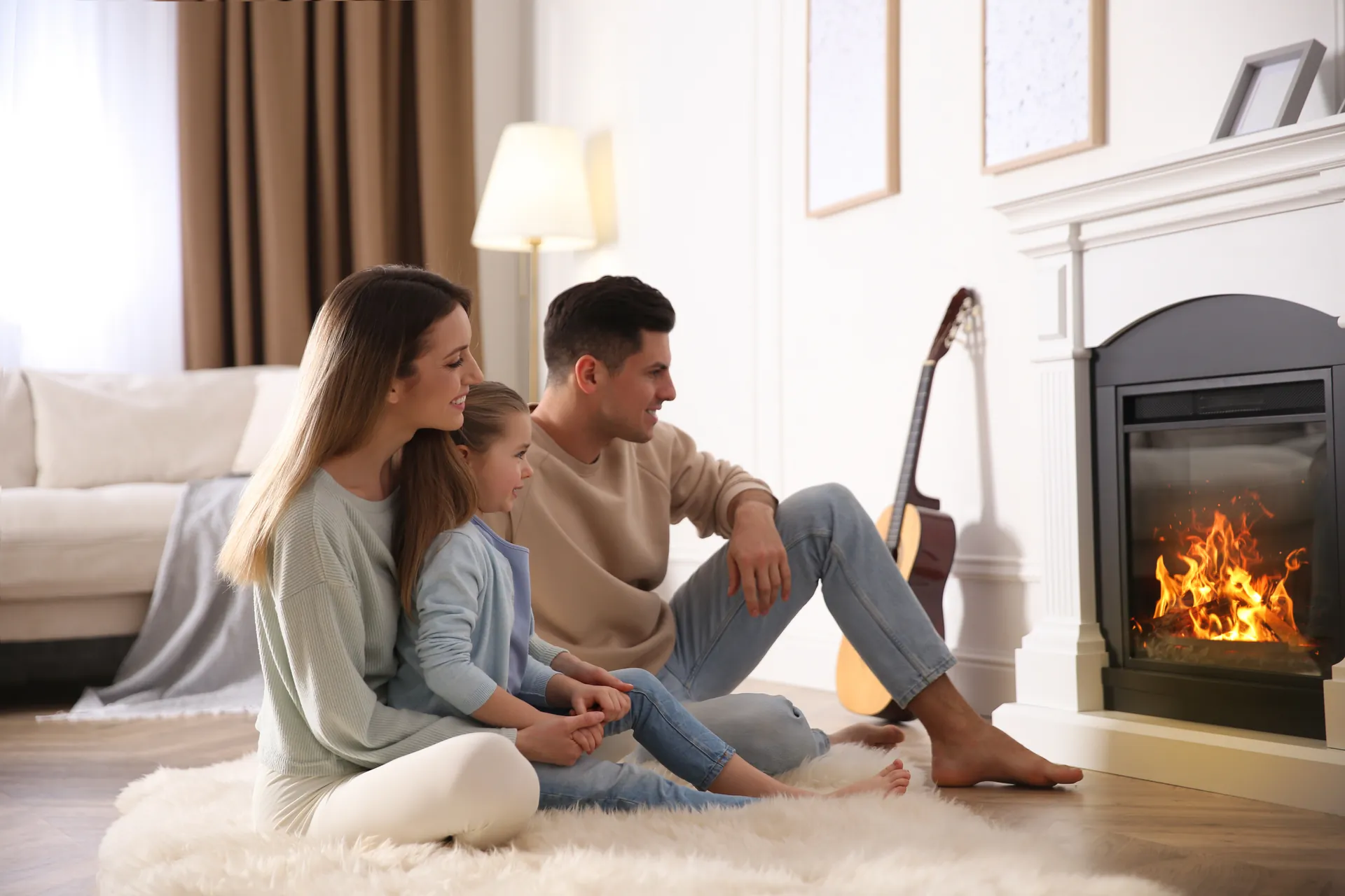 Family relaxing on a sheepskin rug in front of a gas fireplace